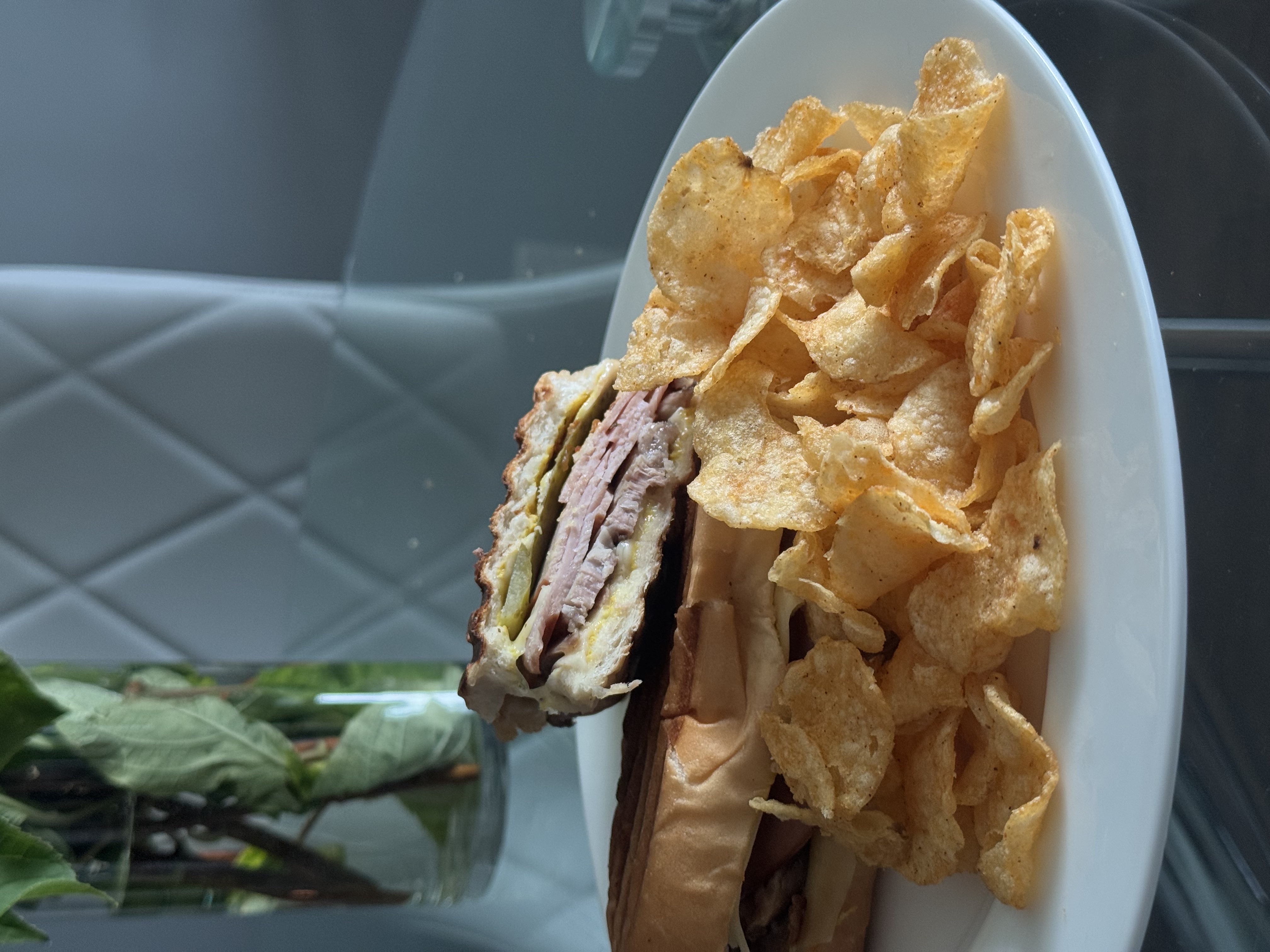 Toasted sandwich plated with chips and Hot Buzz