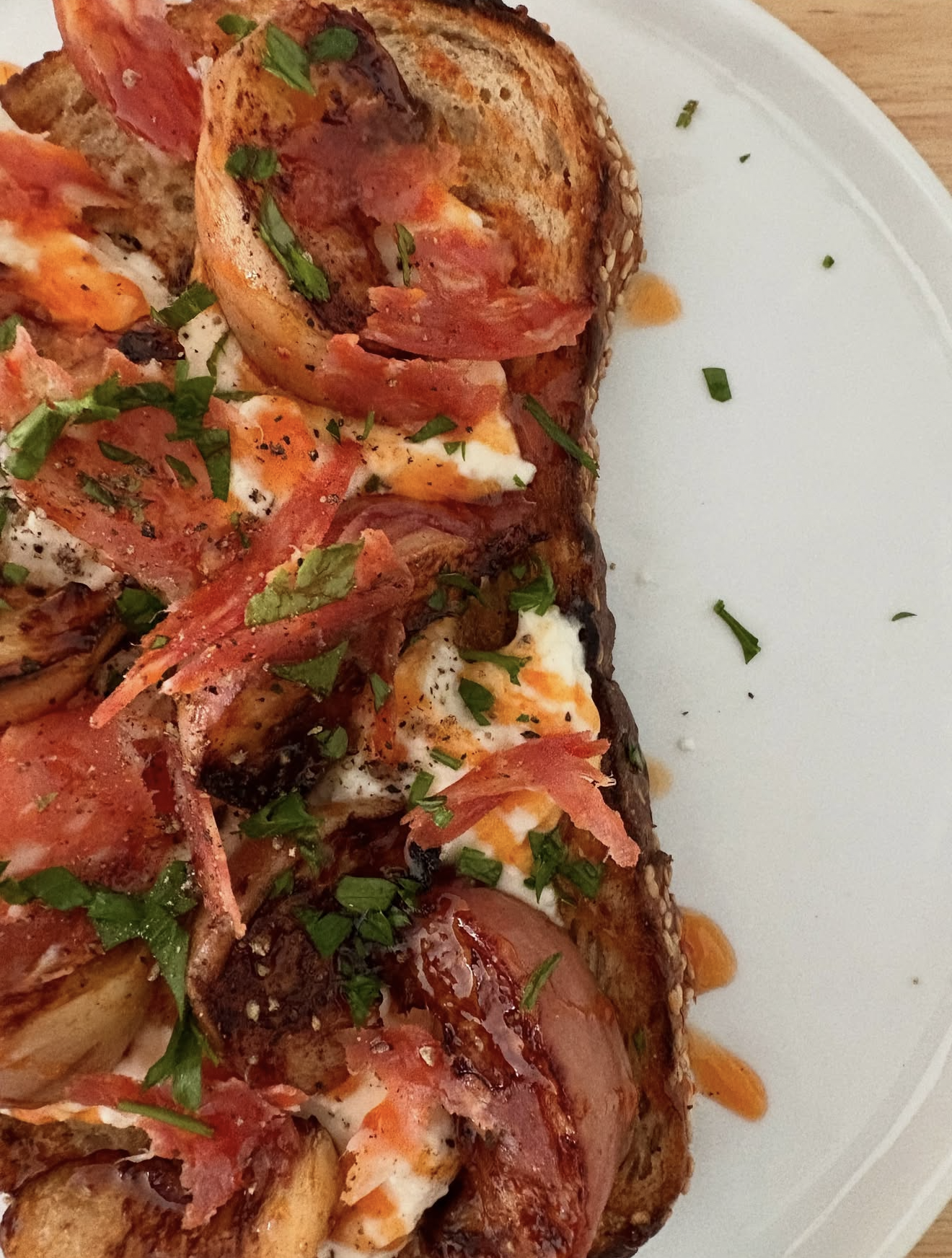 Toast topped with prosciutto and finished with Hot Buzz